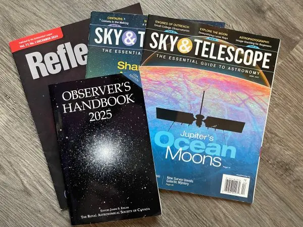 Stack of astronomy publications including Reflector, Sky & Telescope, and the Observer’s Handbook 2025